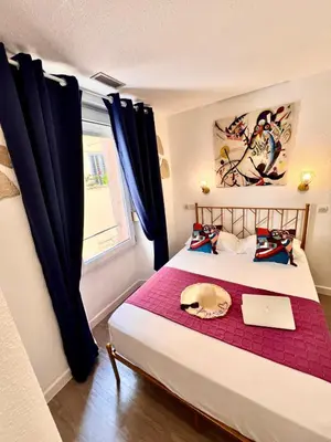 a bedroom with a large white bed in a room at Appia Hotel in Cannes