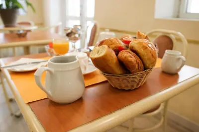 a yellow table with a plate of food on it at Appia Hotel in Cannes