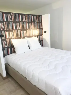a bedroom with a large white bed in front of bookcases at Agence AICI - Appartements Gray d'Albion in Cannes