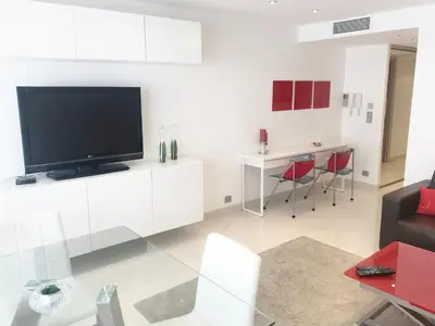 a living room with a flat screen tv on a white wall at Agence AICI - Appartements Gray d'Albion in Cannes