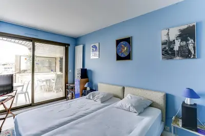 a blue bedroom with a bed and a balcony at Agence AICI - Appartements Gray d'Albion in Cannes