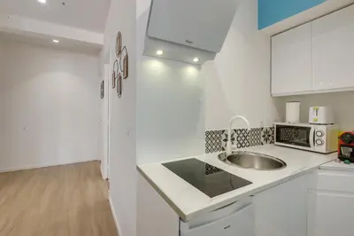 a white kitchen with a sink and a microwave at - Luxury Appart Climatisé Plage - in Cannes