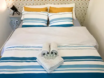 a bed with blue and white striped sheets and towels at - Luxury Appart Climatisé Plage - in Cannes