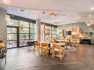 a dining room with tables and chairs and windows at Novotel Suites Cannes Centre in Cannes