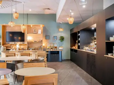 a restaurant with tables and chairs and a counter at Novotel Suites Cannes Centre in Cannes