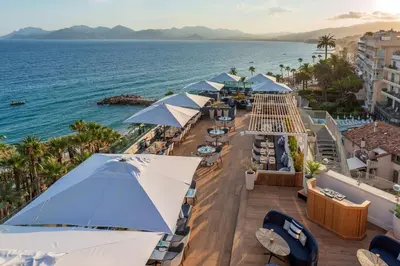 an aerial view of the beach with umbrellas and the ocean at Canopy by Hilton Cannes in Cannes