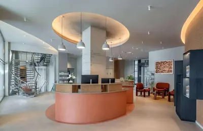 an office lobby with a reception desk and chairs at Canopy by Hilton Cannes in Cannes