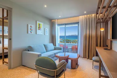 a living room with a couch and a room with a view at Canopy by Hilton Cannes in Cannes