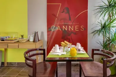 a table with a plate of food and a movie poster at Hotel Le Mistral in Cannes