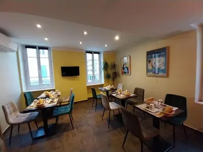 a dining room with tables and chairs with food on them at Hotel Le Mistral in Cannes