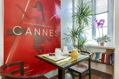 a dining room with a table and a red wall at Hotel Le Mistral in Cannes