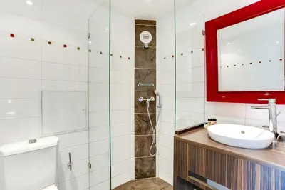 a bathroom with a sink and a shower at Hotel Le Mistral in Cannes