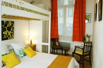 a bedroom with a bed and two chairs and a window at CANNES - À DEUX PAS DU PALAIS DES FESTIVALS in Cannes
