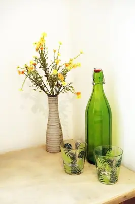three vases and a green bottle on a table at CANNES - À DEUX PAS DU PALAIS DES FESTIVALS in Cannes