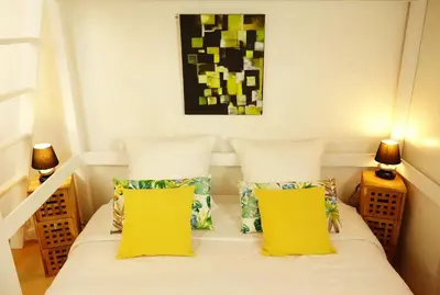 a bedroom with a bed with two yellow pillows at CANNES - À DEUX PAS DU PALAIS DES FESTIVALS in Cannes