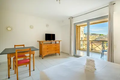 a bedroom with a desk and a table and a window at Residhotel Villa Maupassant in Cannes