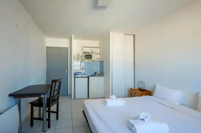 a bedroom with a bed and a table and a kitchen at Residhotel Cannes Festival in Cannes