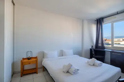 two beds in a room with a window at Residhotel Cannes Festival in Cannes