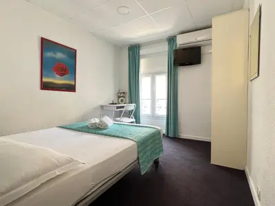 a hotel room with a bed and a window at Little Palace in Cannes