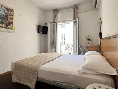 a large bed in a room with a window at Little Palace in Cannes