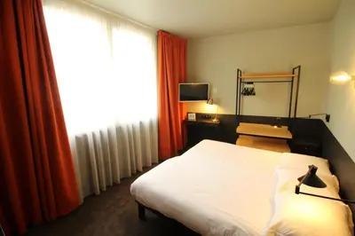 a hotel room with a bed and a window at Hotel Alnea in Cannes