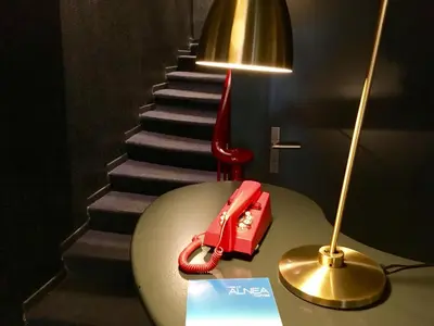 a table with a red phone on it next to a staircase at Hotel Alnea in Cannes