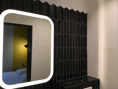 a mirror on a wall in a room with a bed at Hotel Alnea in Cannes