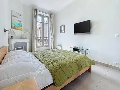 a bedroom with a bed and a flat screen tv at 2 bedroom Forville. 8 mins from the Palais. 328 in Cannes