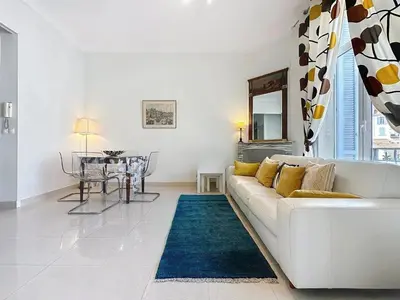 a white living room with a white couch and a table at 2 bedroom Forville. 8 mins from the Palais. 328 in Cannes