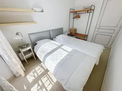 a bedroom with a bed with white sheets and a lamp at 2 bedroom Forville. 8 mins from the Palais. 328 in Cannes