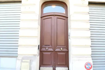 a brown door on the side of a white building at 2 bedroom Forville. 8 mins from the Palais. 328 in Cannes