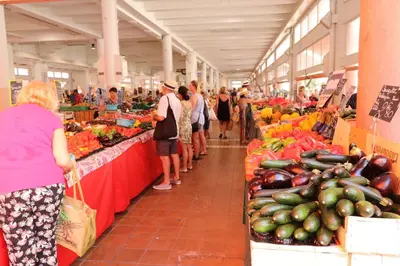 a group of people in a market with fruits and vegetables at 2 bedroom Forville. 8 mins from the Palais. 328 in Cannes