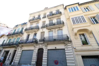 a tall white building with windows and shutters at 2 bedroom Forville. 8 mins from the Palais. 328 in Cannes