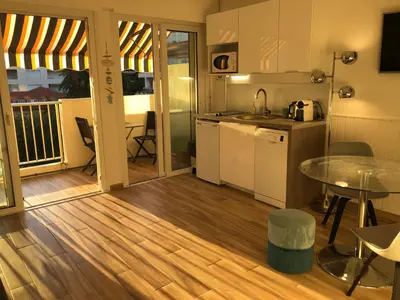 a kitchen and dining area with a table and a table and chairs at Émeraude Croisette in Cannes