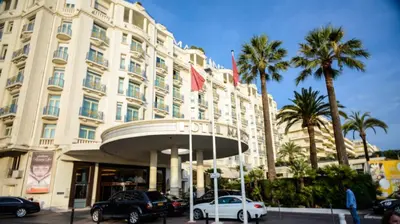a large building with cars parked in front of it at Émeraude Croisette in Cannes