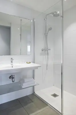 a white bathroom with a sink and a shower at Hotel Abrial by Soniho in Cannes