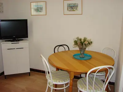 a dining room table with chairs and a television at Good location flat in Cannes