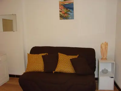 a black couch with yellow pillows in a living room at Good location flat in Cannes