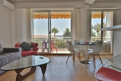 a living room with a couch and a table at 1-Br Apartment Sea View Steps from Beaches in Cannes