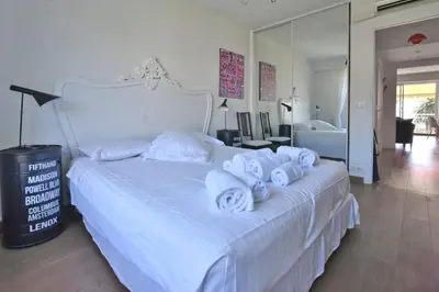 a bedroom with a white bed with towels on it at 1-Br Apartment Sea View Steps from Beaches in Cannes
