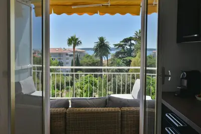 a living room with a couch and a view of the ocean at 1-Br Apartment Sea View Steps from Beaches in Cannes