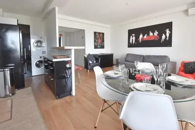 a kitchen and living room with a table and chairs at 1-Br Apartment Sea View Steps from Beaches in Cannes