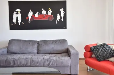 a living room with a couch and a picture of a car at 1-Br Apartment Sea View Steps from Beaches in Cannes