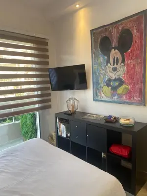 a bedroom with a mickey mouse painting on the wall at Arthur Properties Bel Air in Cannes