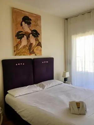 a bed in a bedroom with a painting on the wall at Arthur Properties Bel Air in Cannes