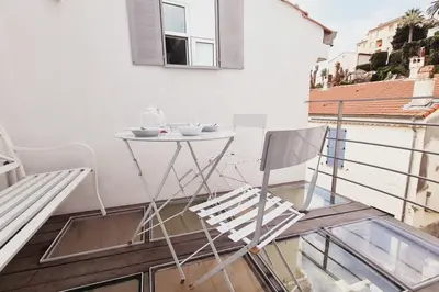 a balcony with a table and chairs on a building at Old harbor 3-bedroom apt charming & unique ! in Cannes