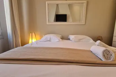 a large bed with two pillows and a mirror at Old harbor 3-bedroom apt charming & unique ! in Cannes
