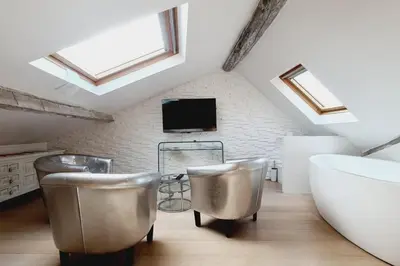 a attic bathroom with silver chairs and a tv at Old harbor 3-bedroom apt charming & unique ! in Cannes