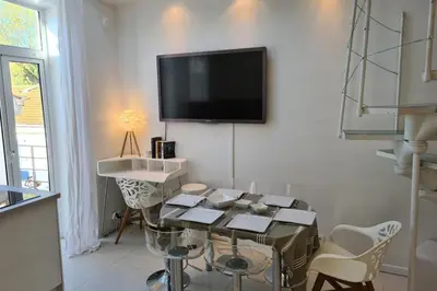 a living room with a tv on the wall at Old harbor 3-bedroom apt charming & unique ! in Cannes