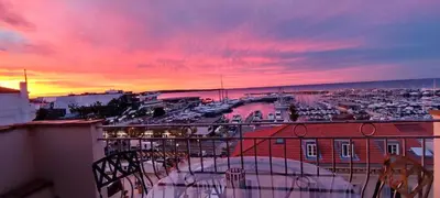 a sunset from a balcony with a view of a harbor at O Festival Palace, terrace with panoramic sea view in Cannes